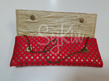 Corner brooch embellished red clutch